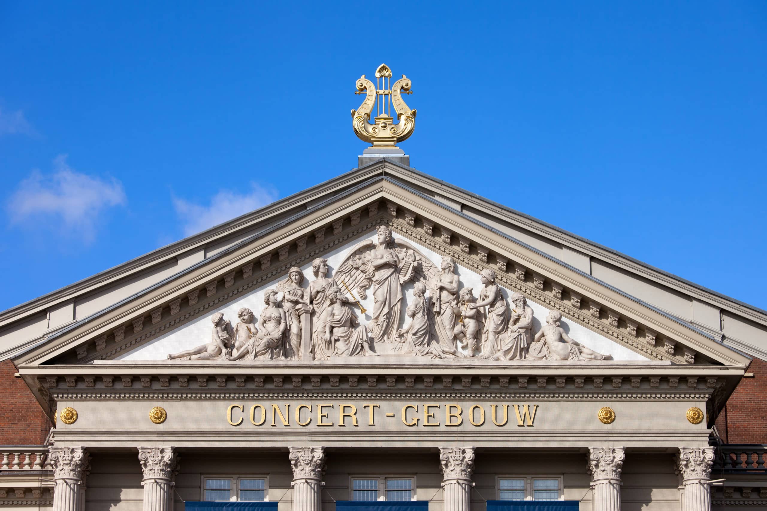 Tympanum with religious reliefs within triangular pediment of the Concertgebouw (concert hall) in Amsterdam, Netherlands, 19th century Neoclassical style.